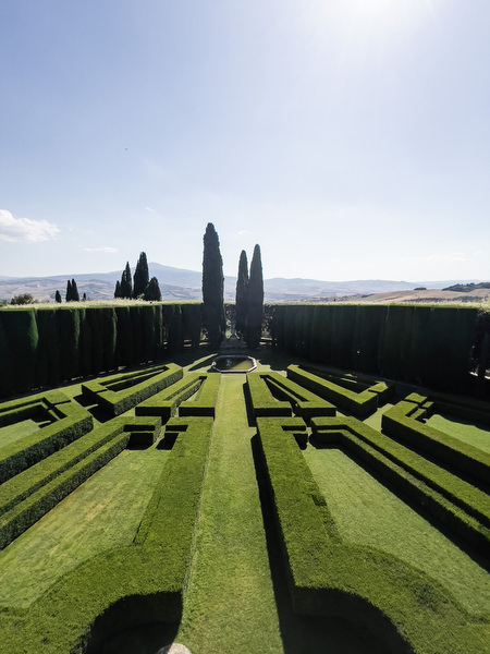 Symmetrical hedge garden at La Foce estate captured in golden Mediterranean light in Tuscany