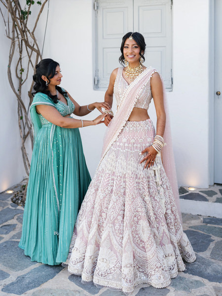 Bride in embroidered blush lehenga preparing for her Hindu ceremony at Island Resort The Residence, Greece