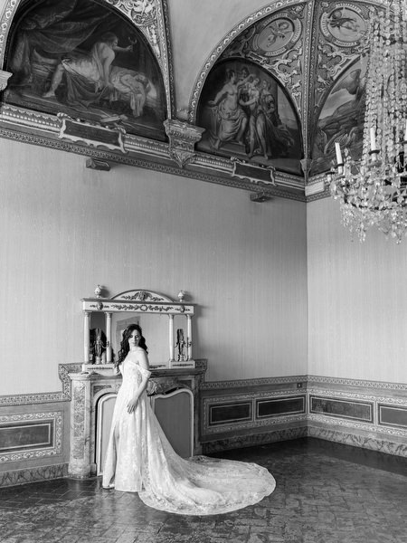 Bride posing inside historic frescoed hall at Villa Corsini a Mezzomonte, luxury Florence wedding venue in Tuscany.