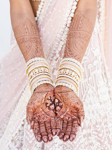 Close-up of intricate mehndi and bridal bangles during a luxury Indian wedding in Athens at Island Resort