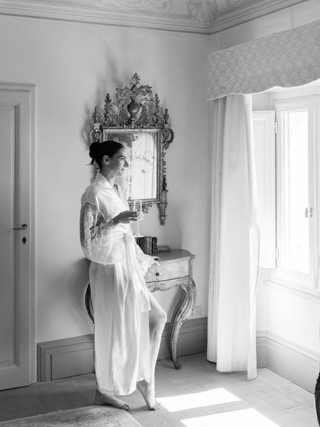 Bride in flowing robe walking through historic La Foce bridal suite before ceremony