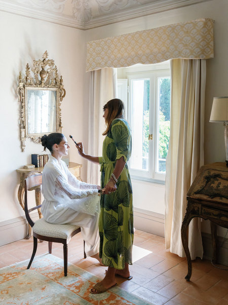 Bridal preparation moment as makeup artist helps the bride get ready inside a Tuscan villa