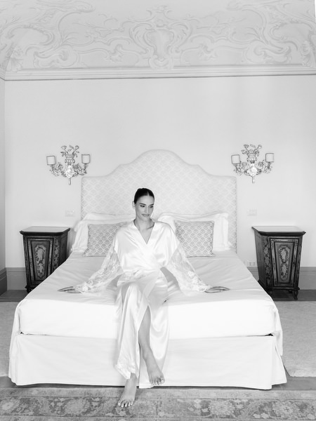 Editorial bridal portrait on a classic Italian bed inside La Foce estate in Tuscany