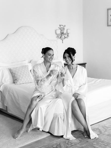 Editorial bridal portrait of bride seated on bed inside historic Tuscan villa at La Foce
