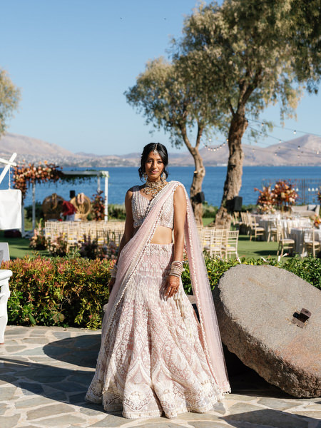 Bride walking toward the ceremony space overlooking the sea at Island Resort The Residence during an Athens Riviera Indian wedding