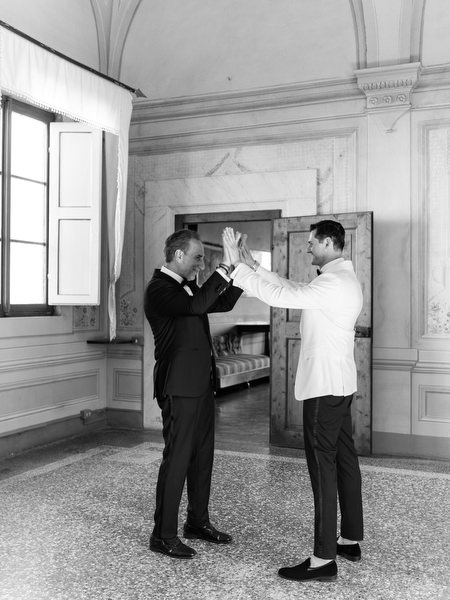Groom and groomsman inside Villa Corsini, luxury Tuscany destination wedding in Florence.