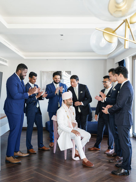 Groom seated with groomsmen during pre-ceremony preparations at Grand Hyatt Athens on the Athens Riviera