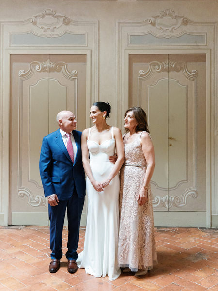 Bride with her parents in a classic portrait inside La Foce estate in Tuscany