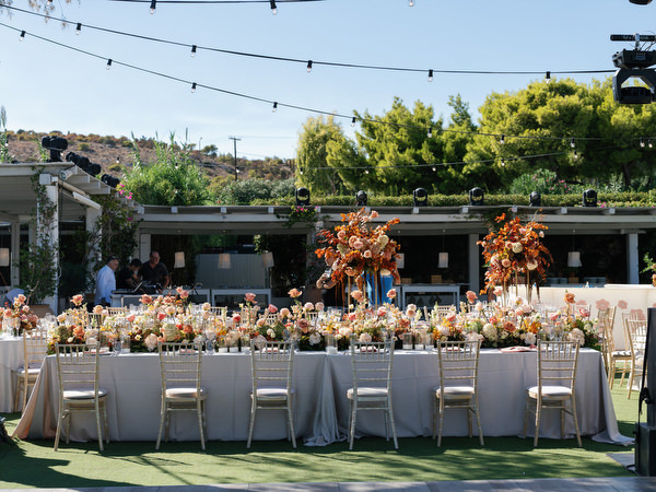 Reception tables styled with warm florals at Island Resort the Residence for an Indian destination wedding in Athens