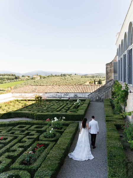 Bride and groom walking through the formal gardens of Villa Corsini a Mezzomonte, Tuscany wedding in Florence.