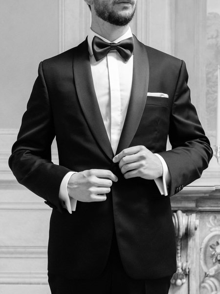 Close-up of groom fastening tuxedo jacket for luxury Tuscany wedding