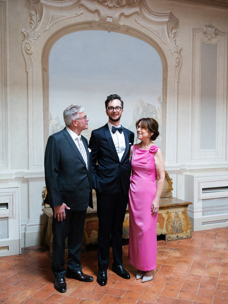 Close-up of groom fastening tuxedo jacket for luxury Tuscany wedding