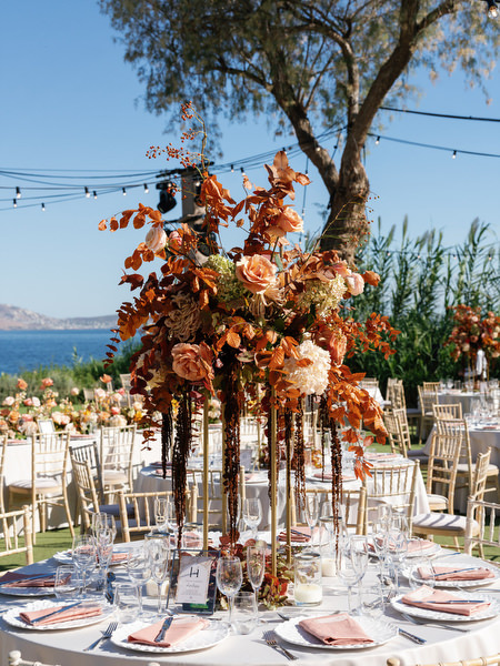 Tall copper-toned floral centerpiece at Island Resort the Residence during a luxury Indian wedding on the Athens Riviera