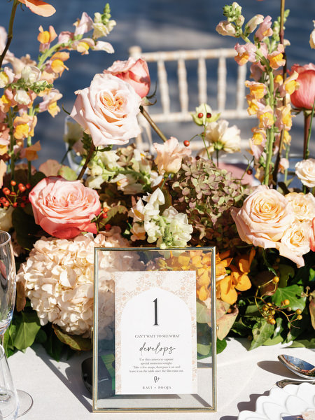 Close-up of table number and floral arrangement at an Athens Riviera Indian wedding at Island Resort