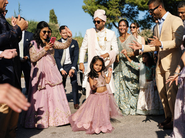 Family and guests dancing during the Indian wedding procession in Athens at Island Resort