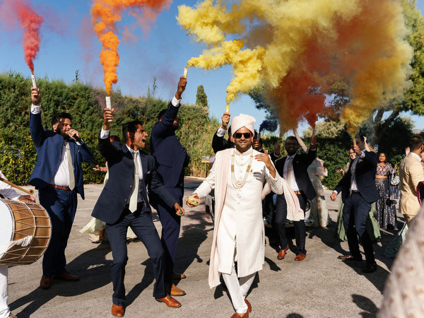 Colorful smoke flares during the baraat at a luxury Indian wedding at Island Resort the Residence