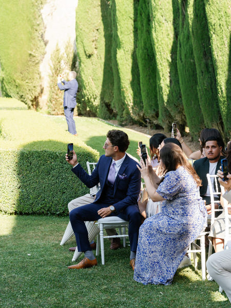 Wedding guests seated in symmetrical Tuscan gardens awaiting the bride’s entrance