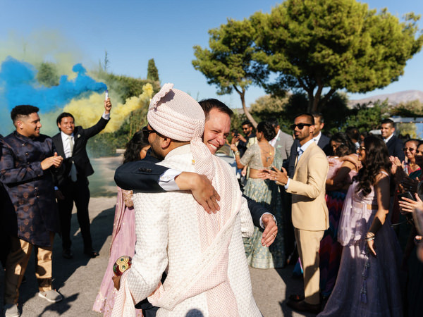 Emotional embrace during the Indian wedding procession at Island Resort the Residence on the Athens Riviera
