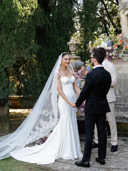 Bride and groom holding hands during emotional outdoor ceremony in Tuscany