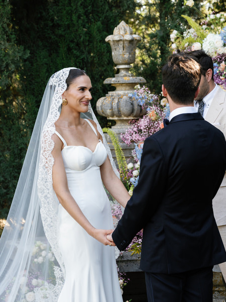 Bride and groom holding hands during emotional outdoor ceremony in Tuscany