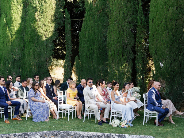 Wedding guests seated among tall cypress hedges during La Foce wedding ceremony