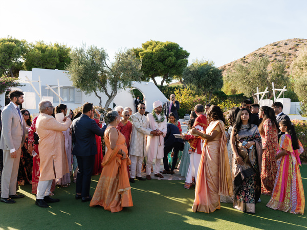 Guests assembling on the seaside lawn at Island Resort the Residence for an Indian wedding in Athens