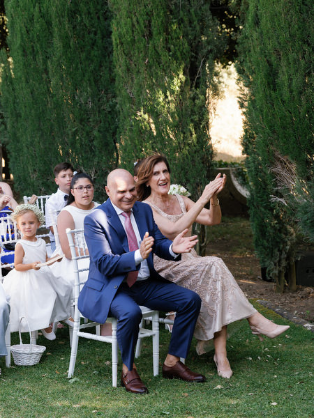 Parents applauding proudly during garden ceremony at La Foce estate