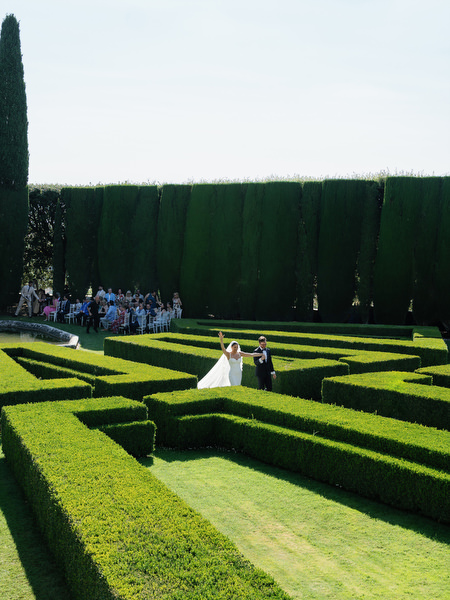 Newlyweds walking down the garden aisle after ceremony at luxury Tuscany wedding in La Foce