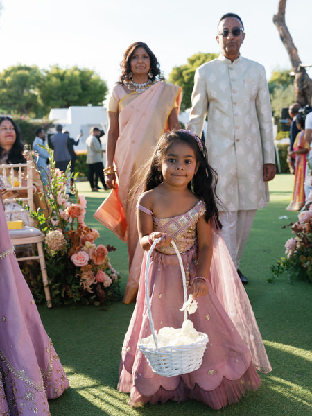 Flower girl walking down the aisle at an Indian destination wedding in Athens at Island Resort