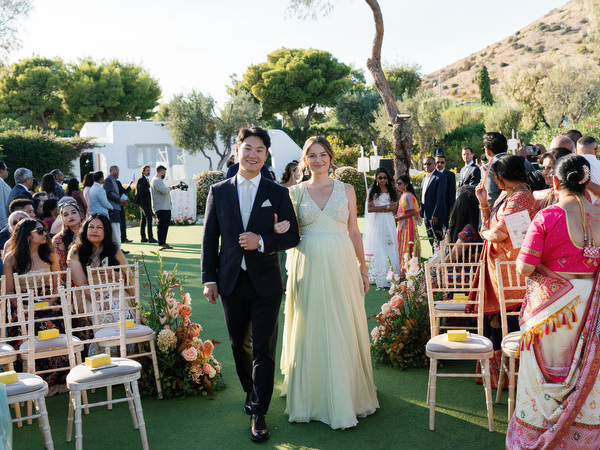 Bridesmaid and groomsman walking down the aisle at Island Resort the Residence on the Athens Riviera