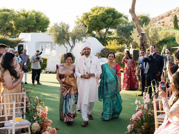 Family members processing down the aisle at Island Resort the Residence for an Indian wedding in Athens