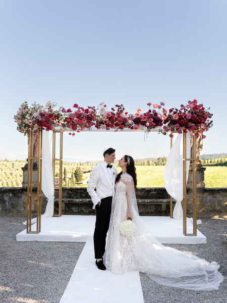 Newlyweds under floral chuppah at Villa Corsini, luxury Tuscany wedding in Florence.