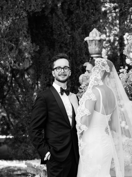 Timeless black and white portrait of bride and groom beneath cathedral veil at La Foce in Tuscany
