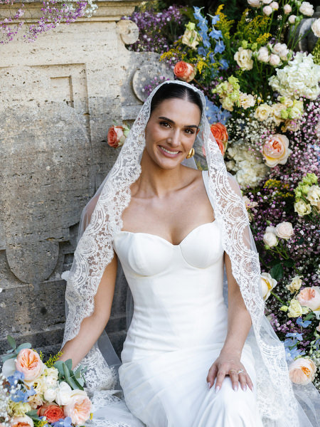 Elegant bridal portrait framed by romantic floral ceremony installation at La Foce estate