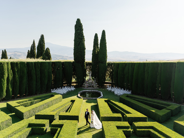 Aerial view of La Foce gardens with bride and groom centered within geometric hedges
