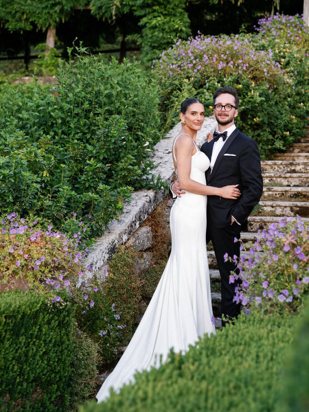 Romantic couple portrait surrounded by lush greenery at luxury Tuscany wedding
