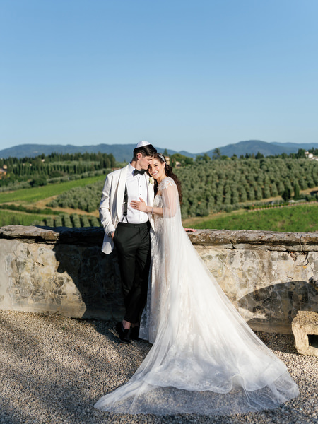 Bride and groom on terrace at Villa Corsini a Mezzomonte overlooking Tuscan vineyards, luxury Jewish wedding in Florence.