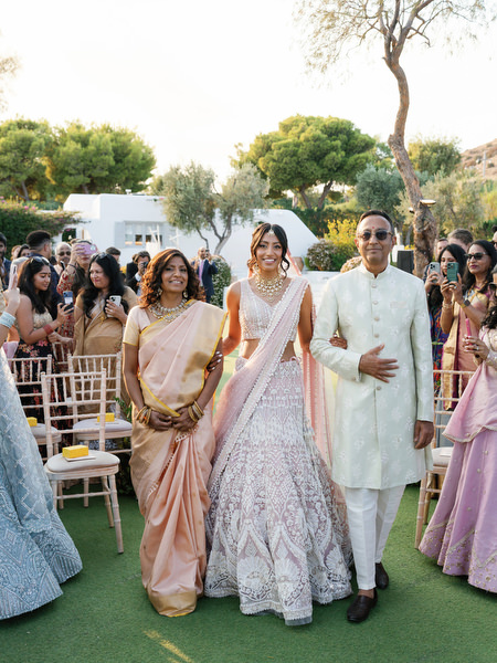 Bride entering the ceremony space with family at Island Resort the Residence on the Athens Riviera