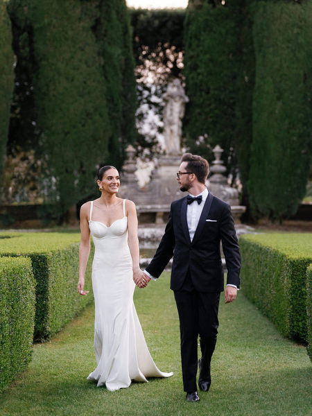 Aerial portrait of newlyweds centered within geometric hedge gardens at La Foce estate
