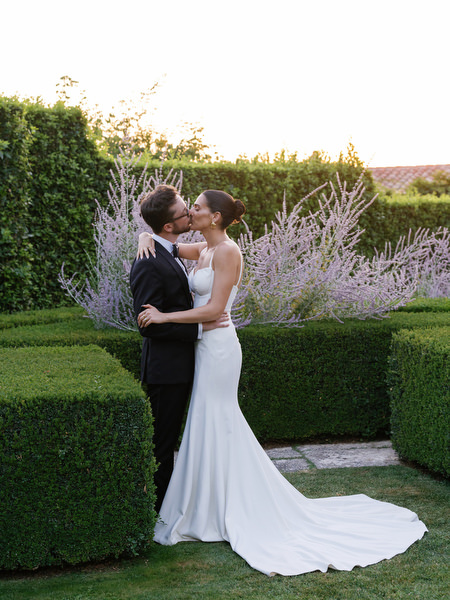 Aerial portrait of newlyweds centered within geometric hedge gardens at La Foce estate