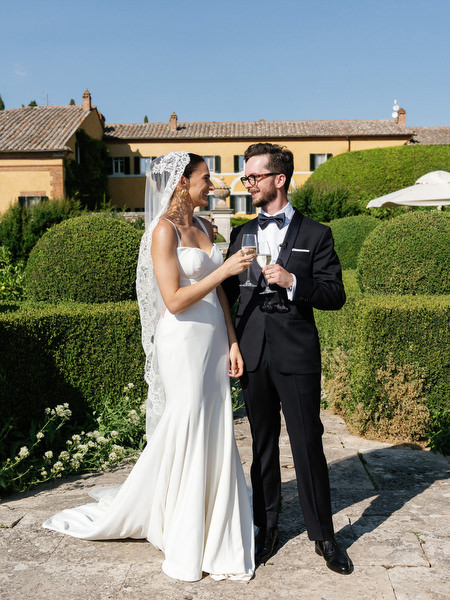 Bride and groom toasting with champagne during golden hour at luxury Tuscany wedding
