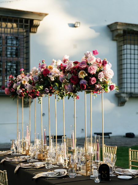 Tall pink wedding floral centerpiece on gold stand at Villa Corsini reception in Florence, Tuscany.