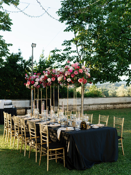 Tuscan villa outdoor wedding dinner at Villa Corsini a Mezzomonte in Florence with tall floral arrangements.