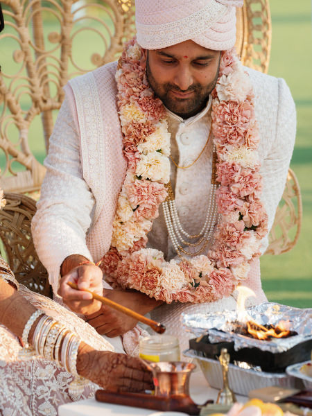 Groom performing fire ritual during the Hindu wedding ceremony at Island Resort the Residence overlooking the sea