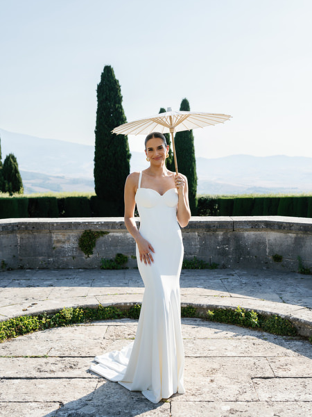 Bride holding a parasol in the Renaissance gardens of La Foce estate