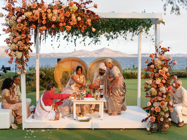 Traditional ritual performed on the mandap stage at Island Resort the Residence during an Indian wedding in Athens