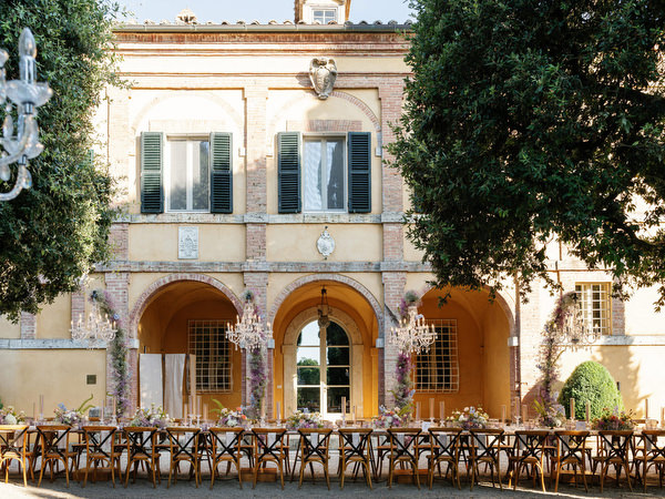 Al fresco reception setup in front of historic villa at La Foce estate in Tuscany