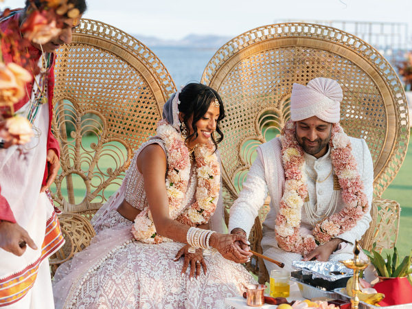 Bride and groom performing sacred fire ritual at Island Resort the Residence on the Athens Riviera