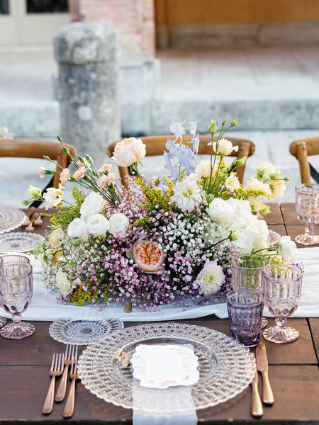 Romantic pastel wedding centerpiece with layered glassware and elegant table styling in Tuscany