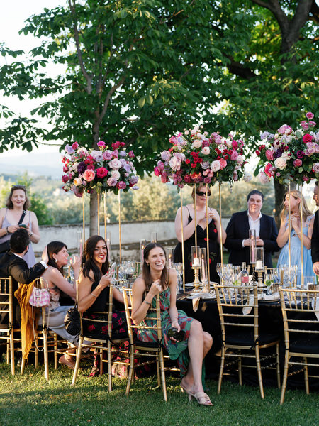 Wedding guests seated beneath pink floral centerpieces at Villa Corsini a Mezzomonte reception in Florence.